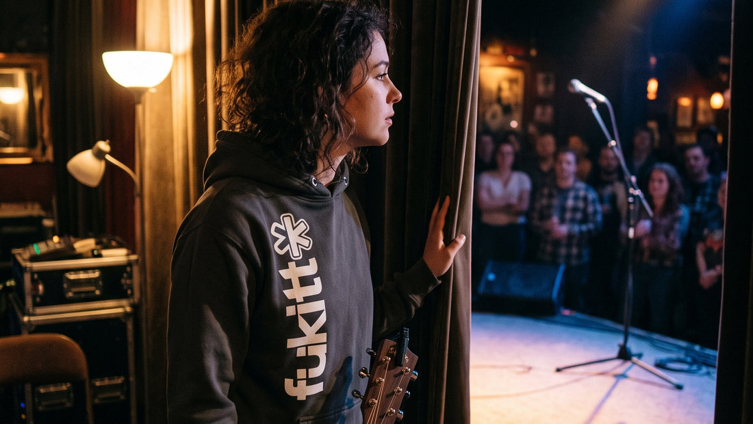 Performer backstage at an open mic in the Fükitt Vertically hoodie, getting ready to go on